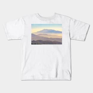 Mountain layers rising to distant peak through hazy light and different color bands. Kids T-Shirt